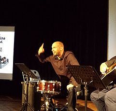 Photographie du spectacle avec deux hommes avec des instruments de musique